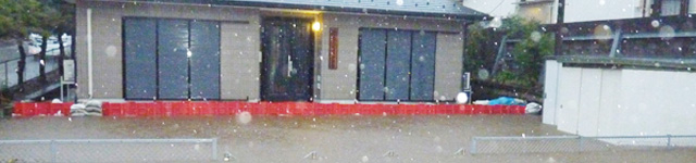 大雨による浸水対策として、住宅の前に並べられたボックスウォールの写真